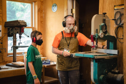 Camper and teacher in woodshop