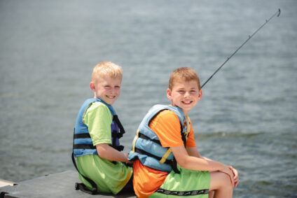 two boys by the lake fishing
